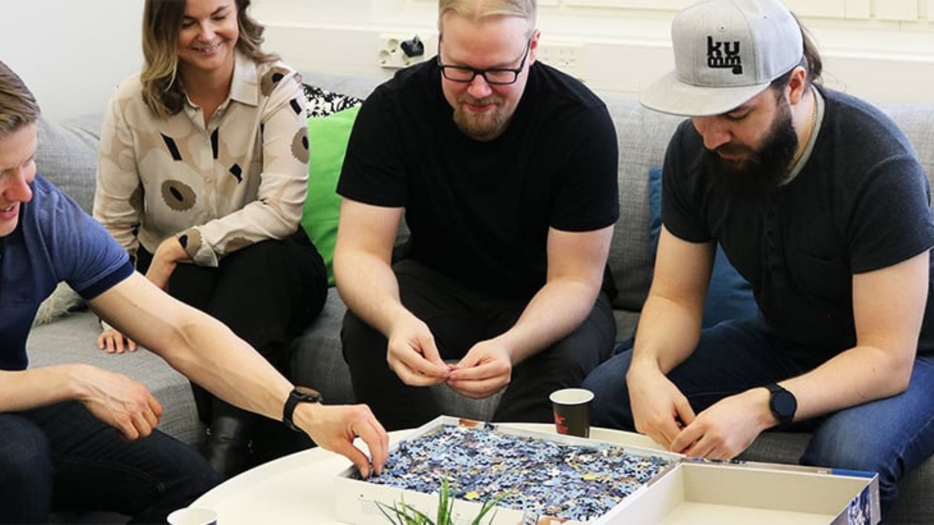 four people playing a puzzle showing the act of balancing work and leisure