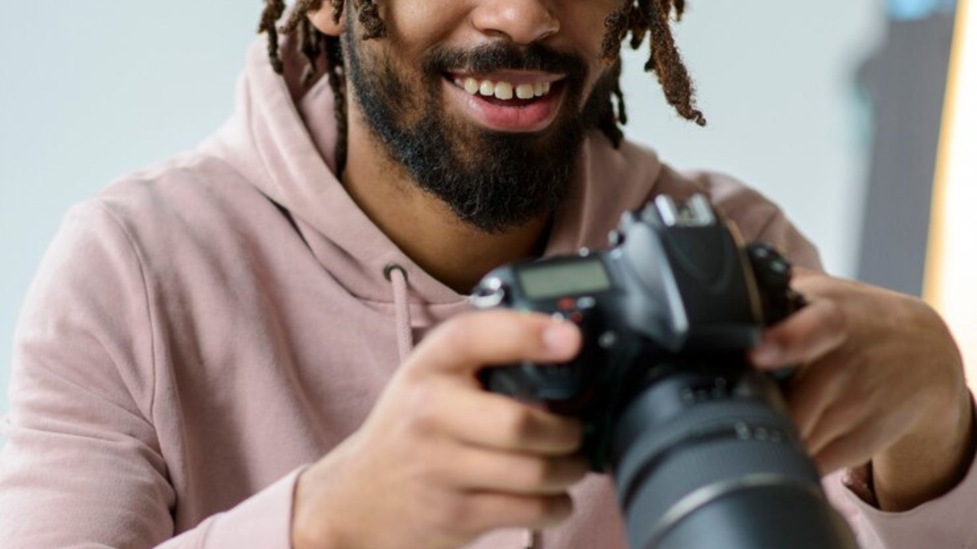 a man with locks holding one of the best cameras for beginners in 2024 