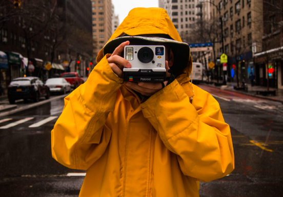 a person wearing a yellow jacket taking a photograph