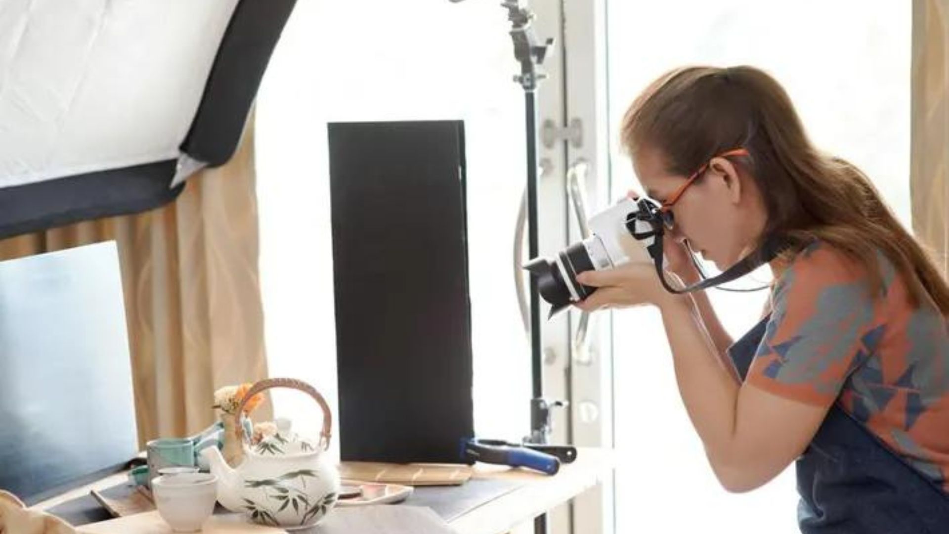 a young lady taking a commercial photography of the products using a camera 